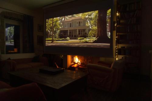 a living room with a fireplace and a television at Casale Le Pietre in Marta