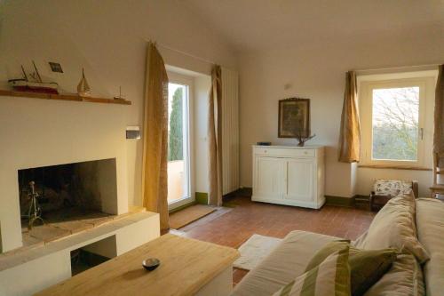 a living room with a couch and a fireplace at Casale Le Pietre in Marta