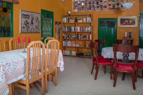 a dining room with a table and chairs and bookshelves at Casa Hudié Campestre in Cachipay