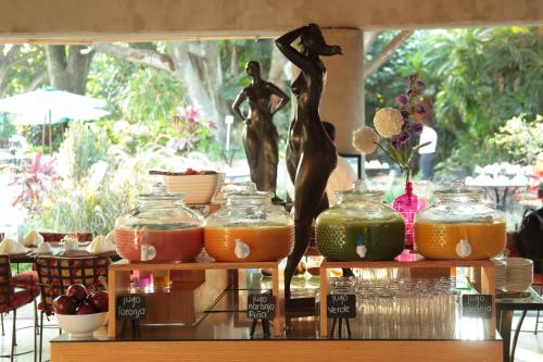 a display of food on a table with a statue at Hosteria Las Quintas Hotel Restaurante Bar in Cuernavaca