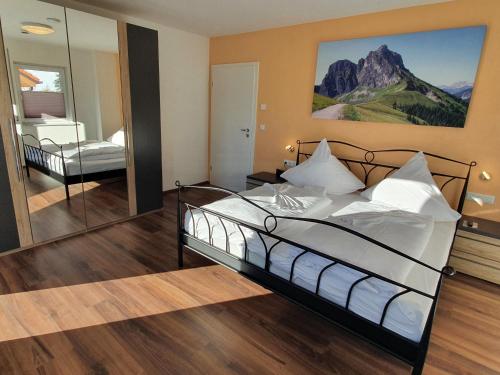 a bedroom with a large bed and a mirror at Ferienhaus Luca in Füssen