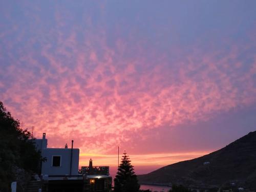 a sunset over a city with a building and a tree at Sun Holiday House in Pisses