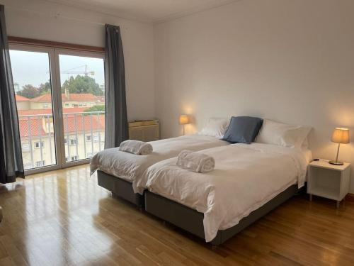 sypialnia z dużym łóżkiem i dużym oknem w obiekcie ASF Brasil w Lizbonie