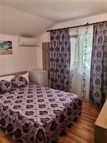 a bedroom with a bed with a black and white quilt at Casa evelin 2mai in 2 Mai
