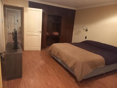 a bedroom with a bed and a flat screen tv at Departamento Residencial in San Fernando del Valle de Catamarca