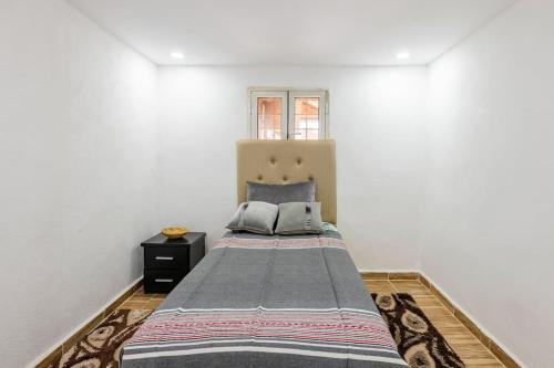 1 dormitorio con 1 cama en una pared blanca en Gîte Nature en Azrou