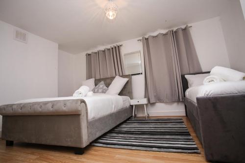 1 Schlafzimmer mit 2 Betten und einem Sofa in der Unterkunft Newly Refurbished 3 Bedroom House close to Central London in London