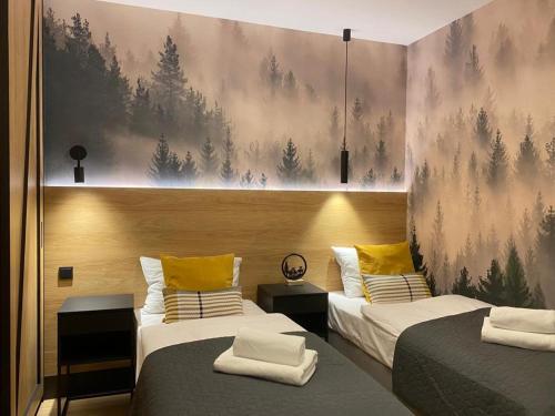 1 dormitorio con 2 camas con almohadas amarillas en REST4U APARTAMENTY z SAUNAMI en Szczyrk