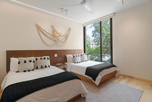 a bedroom with two beds and a large window at 205 Perfect Location 3 bedrooms Apartment in Tulum