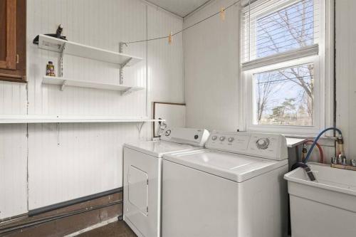 een witte wasruimte met een wasmachine en een raam bij Great Location! Cozy Home with Huge Backyard in Warren