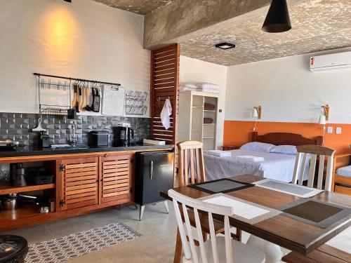 cocina y sala de estar con mesa y cama en Suite Charme apt 10, en Ilhabela