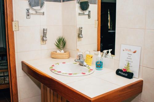 a bathroom counter with a sink and a mirror at Mariposa Jungle Lodge in San Ignacio