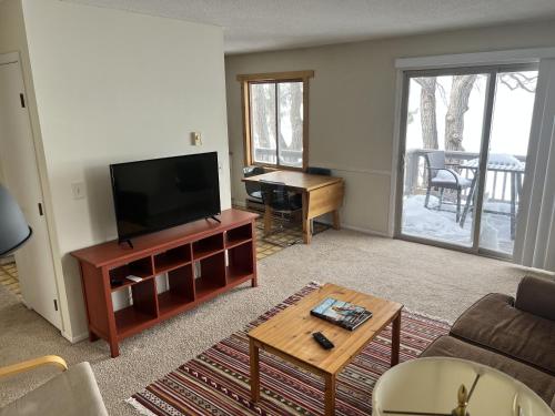 a living room with a flat screen tv and a table at The Point - On Gull Lake in Brainerd
