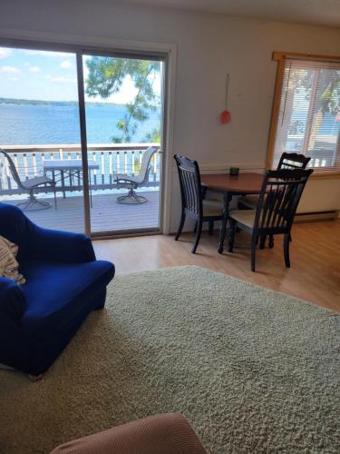 a living room with a table and chairs and a view of the ocean at The Point - On Gull Lake in Brainerd