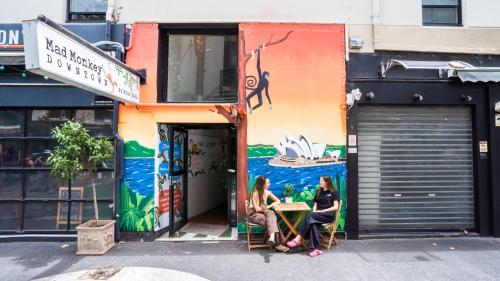 two women sitting at a table in front of a building at Mad Monkey Downtown in Sydney
