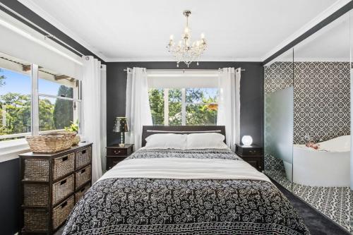 a bedroom with a bed and a chandelier at SUNNYDELL in Bilpin