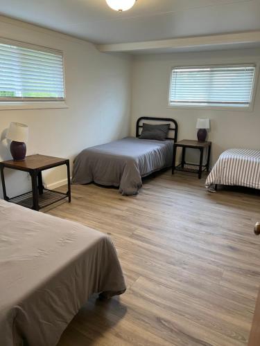 a bedroom with two beds and a wooden floor at Mckinleyville Farm House in McKinleyville