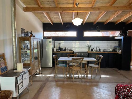 a kitchen with a table and chairs and a refrigerator at Casa Luna in San Pedro de Atacama