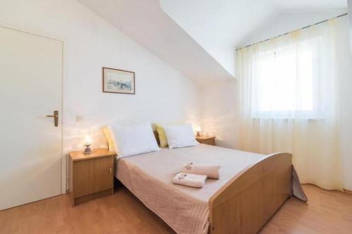 a bedroom with a bed with two towels on it at Family friendly apartments with a swimming pool Supetar, Brac - 16774 in Supetar