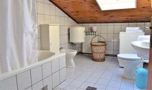 ein Badezimmer mit 2 WCs, einer Badewanne und einem Waschbecken in der Unterkunft Apartments with a parking space Kampor, Rab - 5000 in Rab
