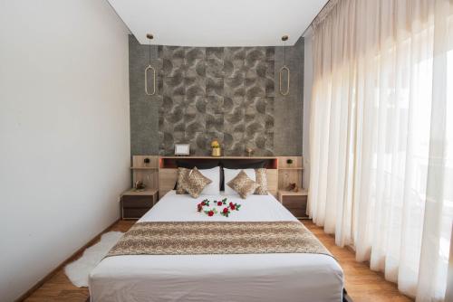 a bedroom with a bed with flowers on it at Next Home - Airport in Nouaseur