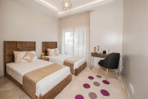 una camera con 2 letti, una scrivania e una sedia di Luxury Apartment Airport a Nouaseur