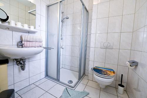 ein Bad mit einer Dusche, einem WC und einem Waschbecken in der Unterkunft Haus am Waldbad AW15 in Cuxhaven