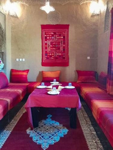 - un salon avec des canapés rouges et une table dans l'établissement Oasis Home, à Moulay Ali Chérif