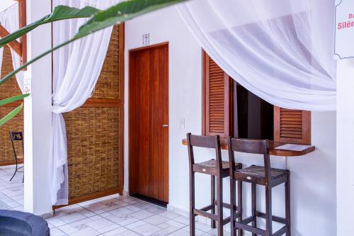a room with a table and two chairs and a door at Pousada Vila Barequeçaba in São Sebastião