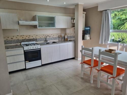 a kitchen with a stove and a table with chairs at Departamento centro in General Juan Madariaga