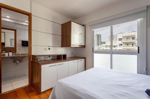 1 dormitorio con cama blanca y baño en Apt completo com piscina e área de lazer em BOTAFOGO, en Río de Janeiro