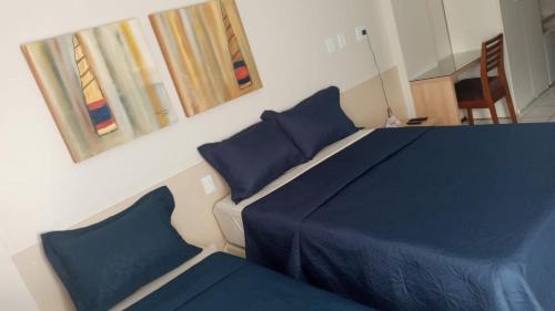 1 dormitorio con cama azul y almohadas azules en Gran Lençóis Flat Residence Apartamento Atins 109 en Barreirinhas