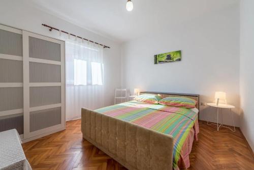 a bedroom with a bed and a table and a window at Family-friendly apartments with swimming pool Stara Vas, Pag - 21031 in Pag