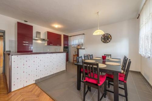 a dining room and kitchen with a table and chairs at Family-friendly apartments with swimming pool Stara Vas, Pag - 21031 in Pag