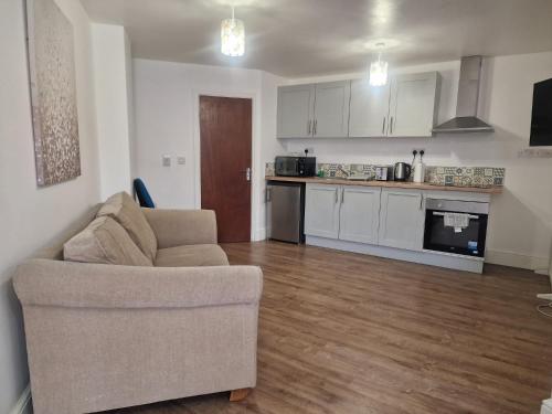 a living room with a couch and a kitchen at Lovely 1 bedroom apartment in Bristol