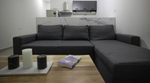 a black couch in a living room with a table at Sogni D' Oro "Zen" in Zakynthos