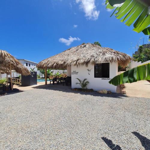 a building with a straw hut with a table and chairs at BUNGALOWS COLIBRI in Las Galeras