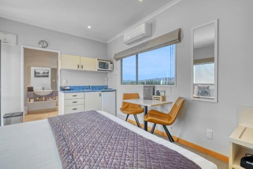 a bedroom with a bed and a table with chairs at Hanmer Springs Scenic Views Motel in Hanmer Springs