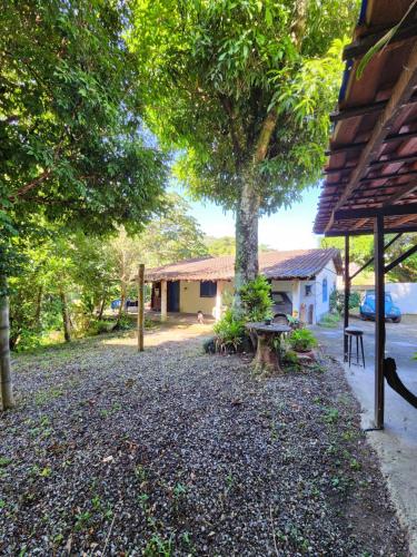 un patio con un árbol y un edificio en Hospedaria e Camping Quintal do Mundo en Lumiar