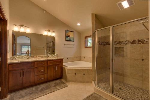 La salle de bains est pourvue d'une douche, d'un lavabo et d'une baignoire. dans l'établissement Cozy Penthouse W Fireplace, Wifi, Gourmet Kitchen, à South Lake Tahoe
