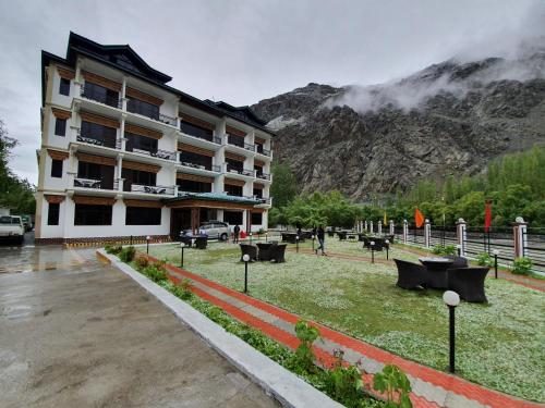 a building with a park in front of a mountain at Hotel Chhutuk Heights in Kargil
