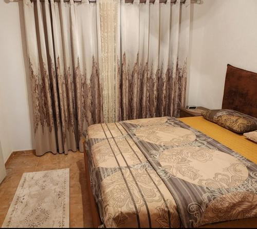 a bedroom with a bed and a window with curtains at Apartments Ishmi in center of Ulcinj in Ulcinj