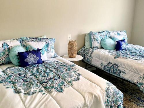 a bedroom with two beds with blue and white pillows at Third Floor Score in Calabash