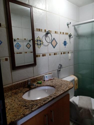 a bathroom with a sink and a shower and a mirror at Marsallis Residence Flat-EFM601 in Natal