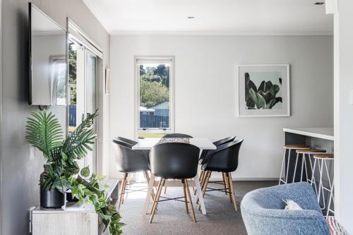 a dining room with a table and chairs at Seagreen Bach in Raglan
