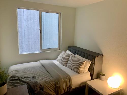 Dormitorio pequeño con cama y ventana en Private Room at The Zen Den en Ciudad de México