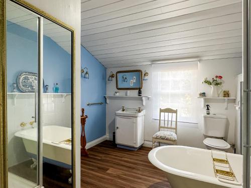 uma casa de banho com uma banheira, um WC e um lavatório. em Alice's Cottages em Launceston