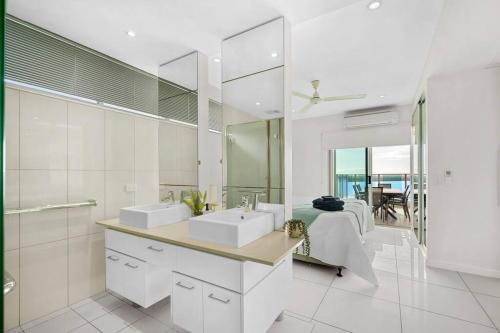 a bathroom with two sinks and a large mirror at Spectacular Darwin apartment in Darwin