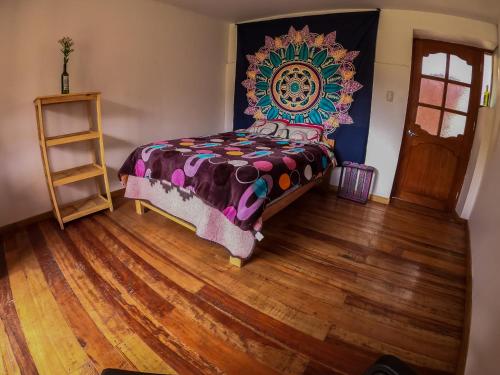 1 dormitorio con 1 cama y suelo de madera en Tayta Wasi Rent Pisac, en Písac