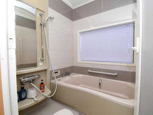 a bathroom with a bath tub with a large window at 宿樽 in Kanazawa